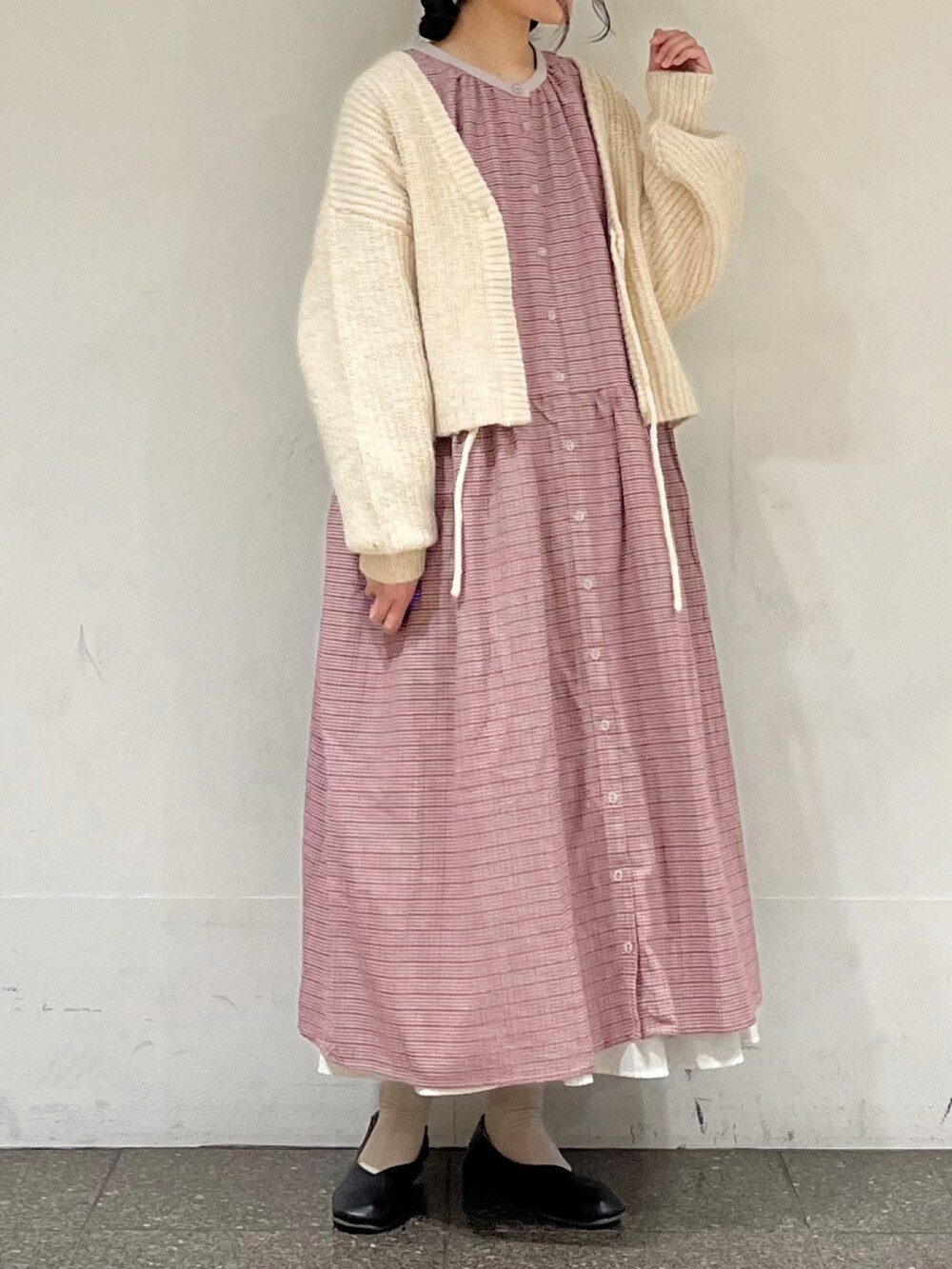 レッド系のワンピース、ホワイト系のカーディガン/ボレロ、ホワイト系のスカートを着用したレディースの冬コーディネートの2枚目の写真