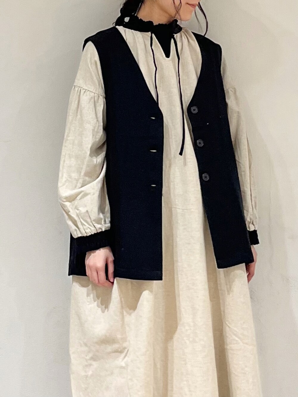 ベージュ系のワンピース、ブラック系のTシャツ/カットソー、ホワイト系のその他パンツを着用したレディースの冬コーディネートの4枚目の写真