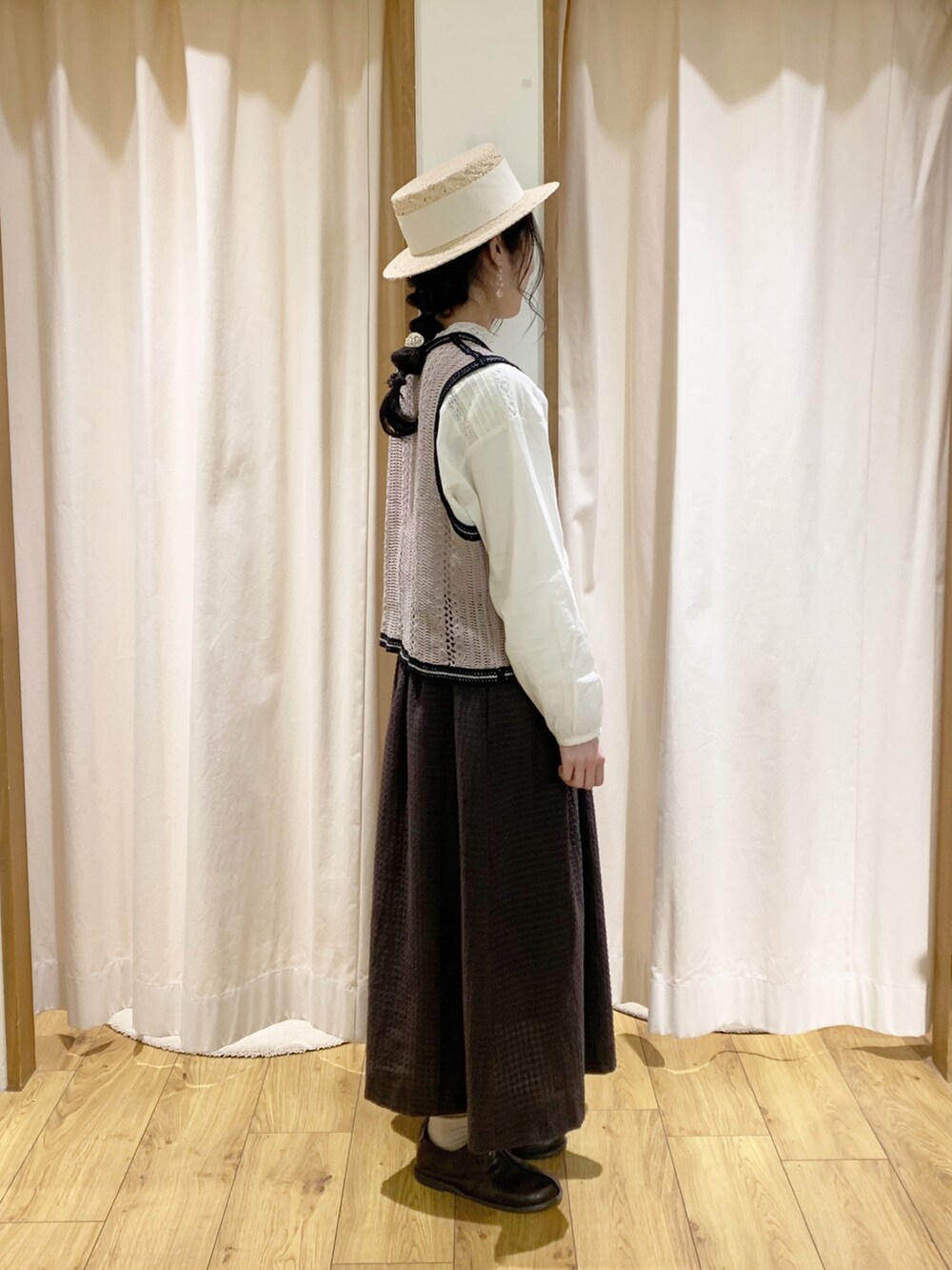 ベージュ系のベスト、ホワイト系のシャツ/ブラウス、グレー系のスカートを着用したレディースの春コーディネートの3枚目の写真