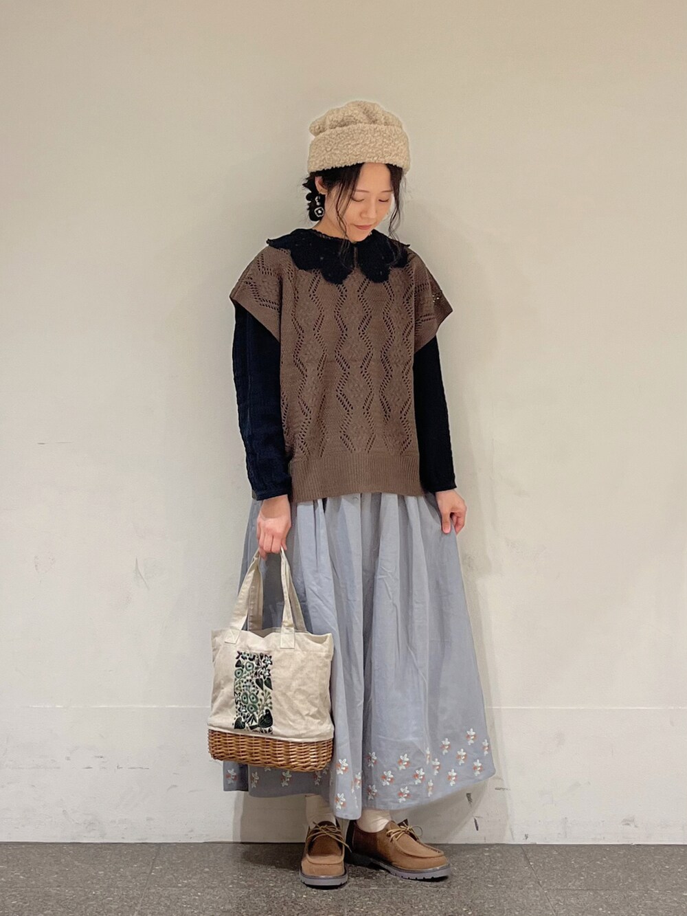 ブラック系のシャツ/ブラウス、ブラウン系のベスト、ブルー系のスカートを着用したレディースの秋コーディネートの3枚目の写真