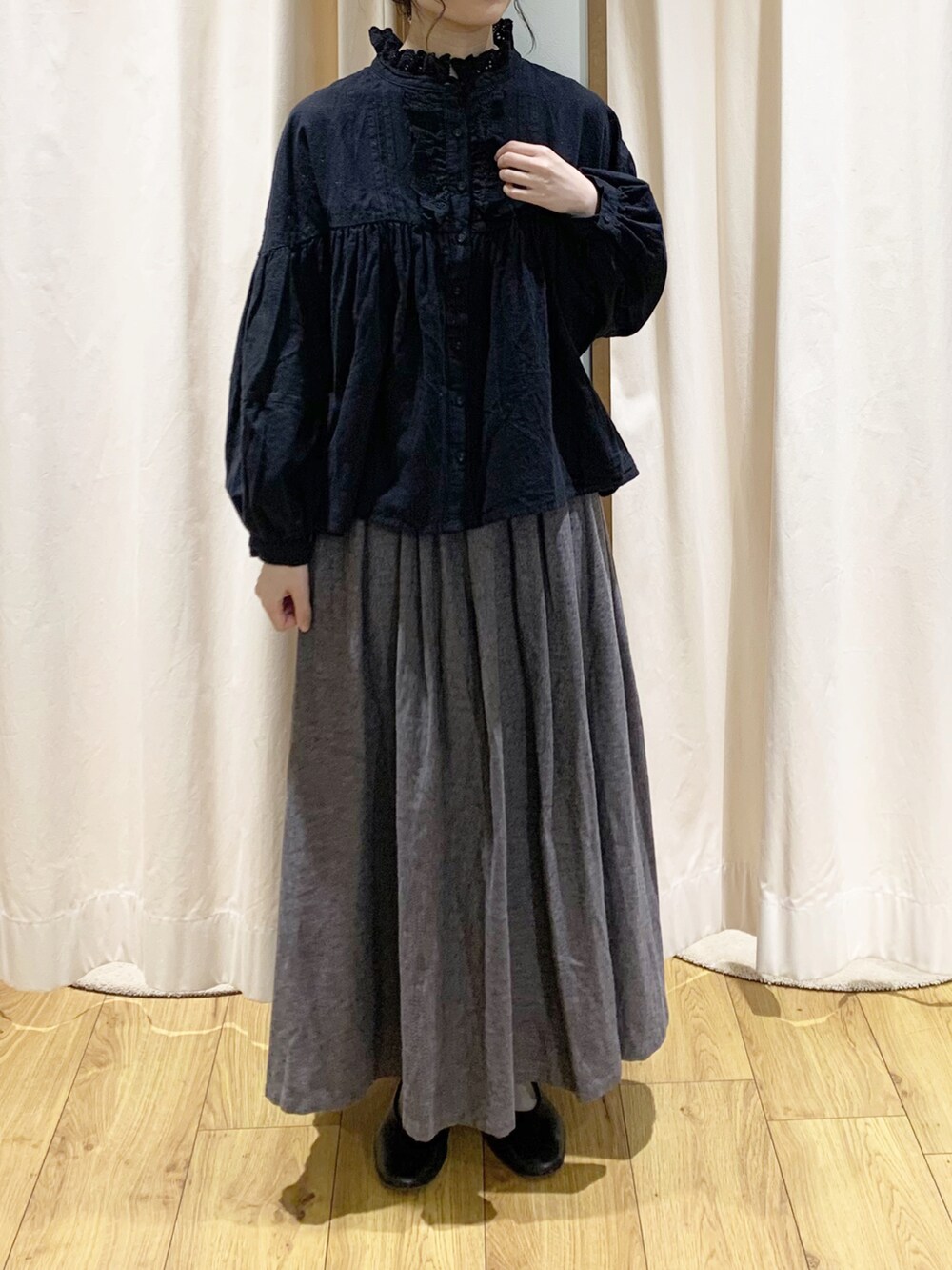 グレー系のカーディガン/ボレロ、ブラック系のシャツ/ブラウス、グレー系のスカートを着用したレディースの秋コーディネートの4枚目の写真