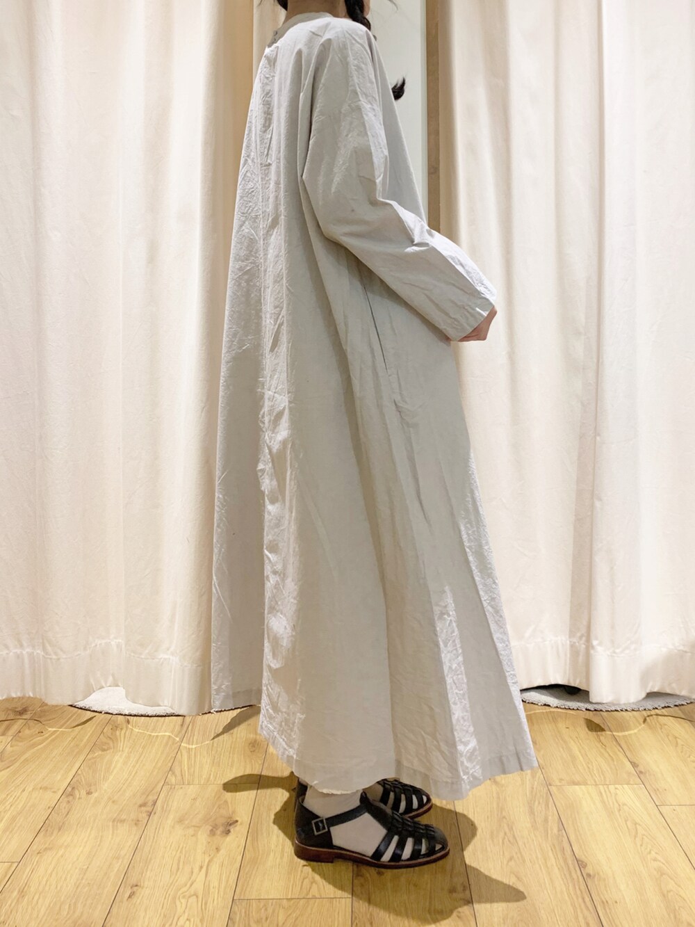 グレー系のワンピース、ブラック系のサンダル、ホワイト系のスカートを着用したレディースの春コーディネートの3枚目の写真