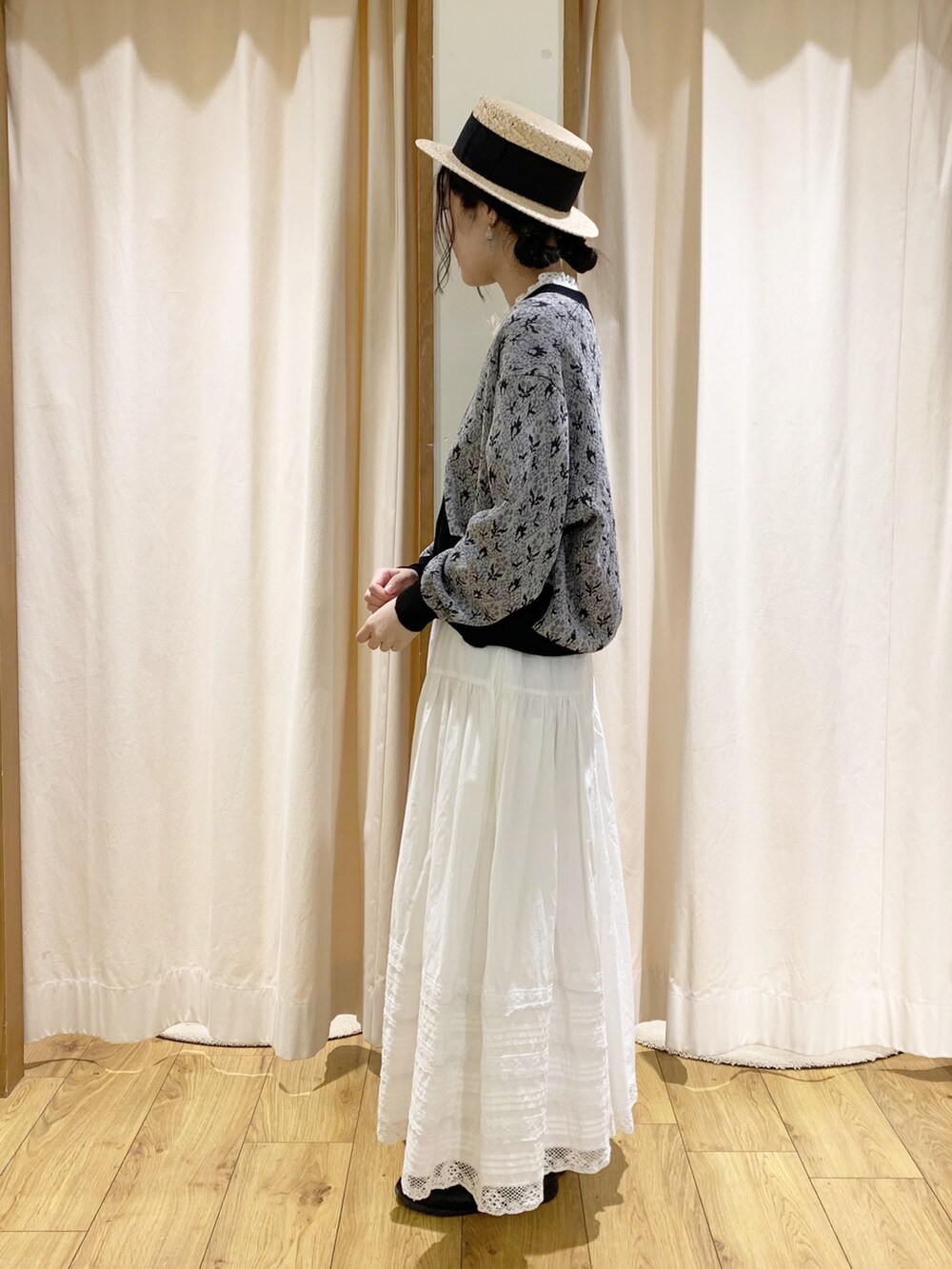 ブラック系のカーディガン/ボレロ、ホワイト系のスカート、ホワイト系のタンクトップを着用したレディースの春コーディネートの3枚目の写真