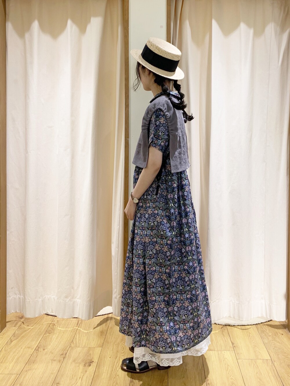 ブルー系のワンピース、グレー系のベスト、ホワイト系のスカートを着用したレディースの春コーディネートの2枚目の写真