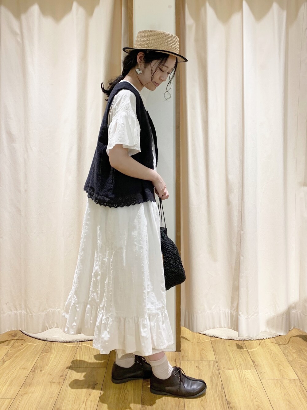 グレー系のベスト、ホワイト系のワンピース、ホワイト系のTシャツ/カットソーを着用したレディースの春コーディネートの3枚目の写真