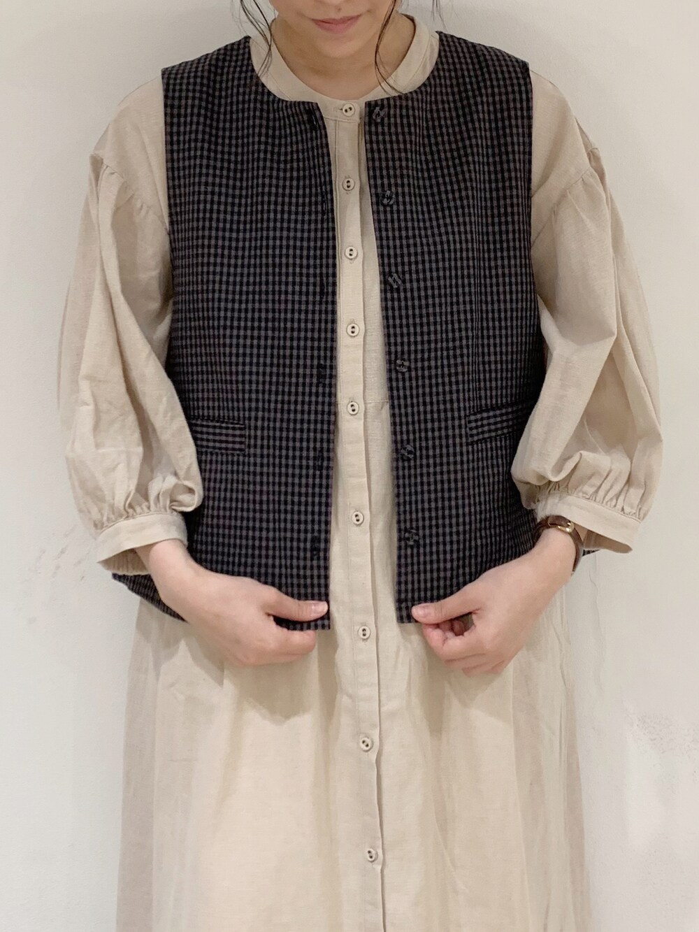 グレー系のベスト、ベージュ系のワンピース、ホワイト系のTシャツ/カットソーを着用したレディースの夏コーディネートの4枚目の写真