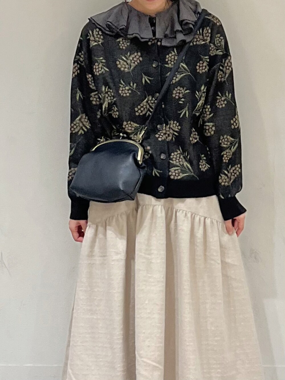 ブラック系のカーディガン/ボレロ、グレー系のシャツ/ブラウス、ホワイト系のスカートを着用したレディースの冬コーディネートの5枚目の写真