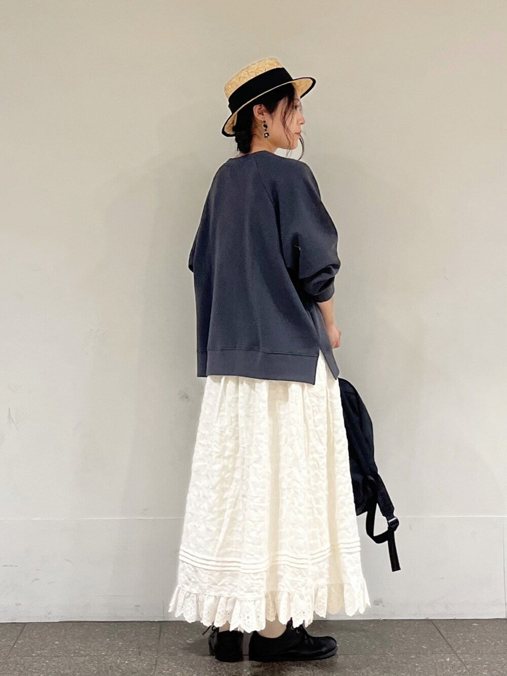 グレー系のTシャツ/カットソー、ホワイト系のスカート、ブラック系のハンドバッグを着用したレディースの冬コーディネートの4枚目の写真