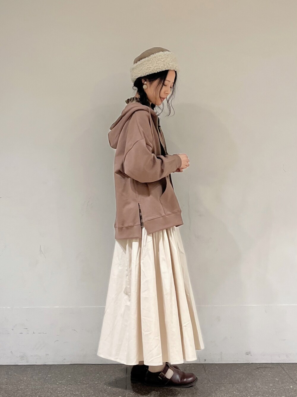 ブラウン系のシャツ/ブラウス、ベージュ系のスカート、ブラウン系のTシャツ/カットソーを着用したレディースの秋コーディネートの2枚目の写真