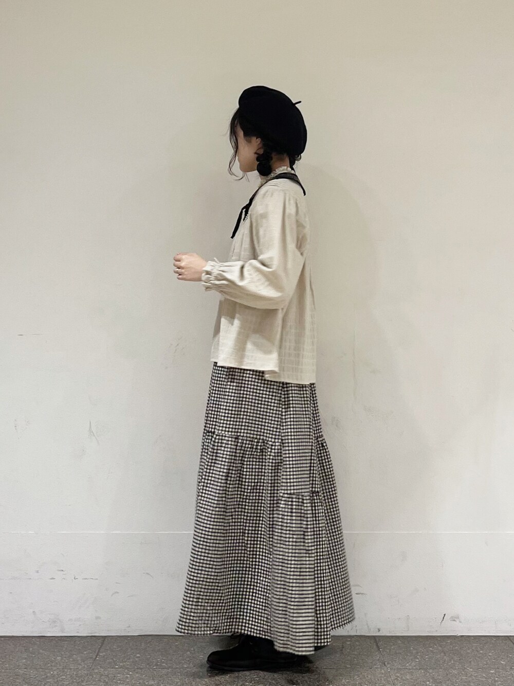 ベージュ系のシャツ/ブラウス、ブラック系のスカート、グレー系のカーディガン/ボレロを着用したレディースの冬コーディネートの2枚目の写真