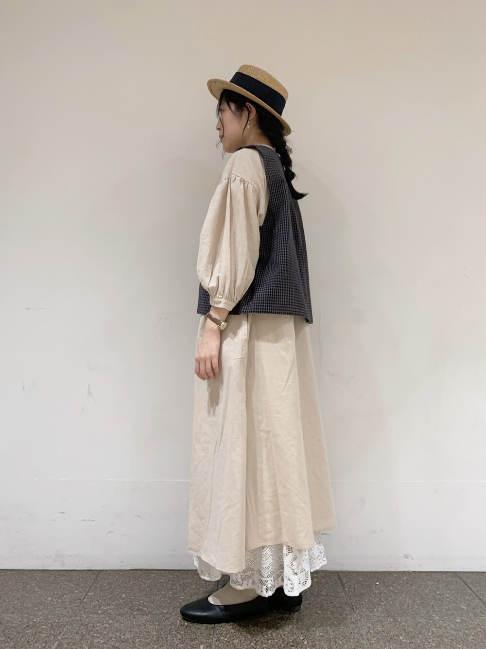 グレー系のベスト、ベージュ系のワンピース、ホワイト系のTシャツ/カットソーを着用したレディースの夏コーディネートの2枚目の写真