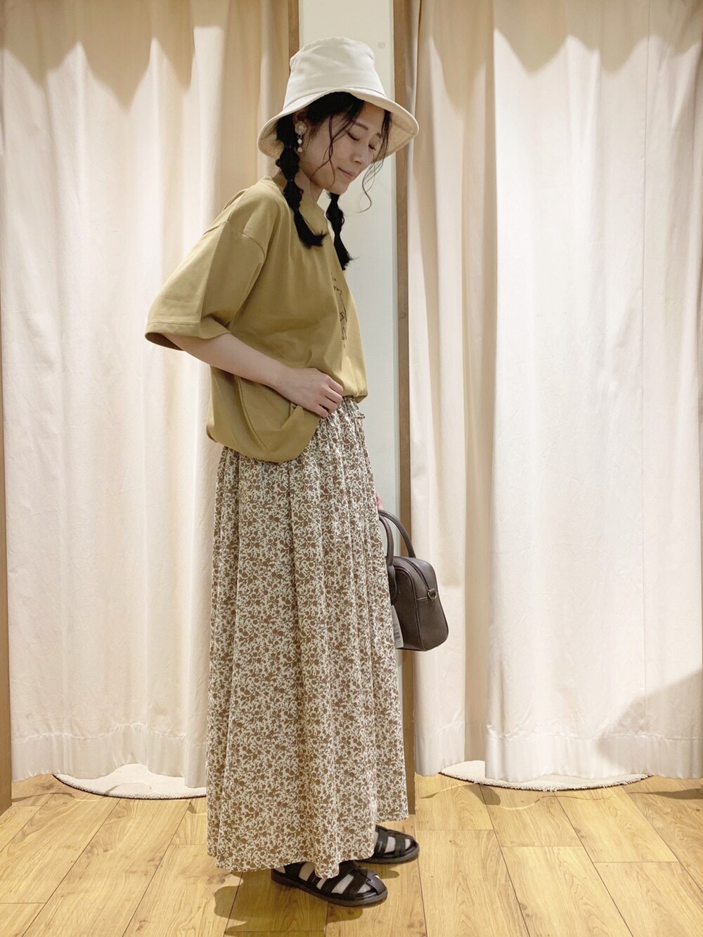 イエロー系のTシャツ/カットソー、オレンジ系のスカート、ホワイト系のTシャツ/カットソーを着用したレディースの春コーディネートの3枚目の写真