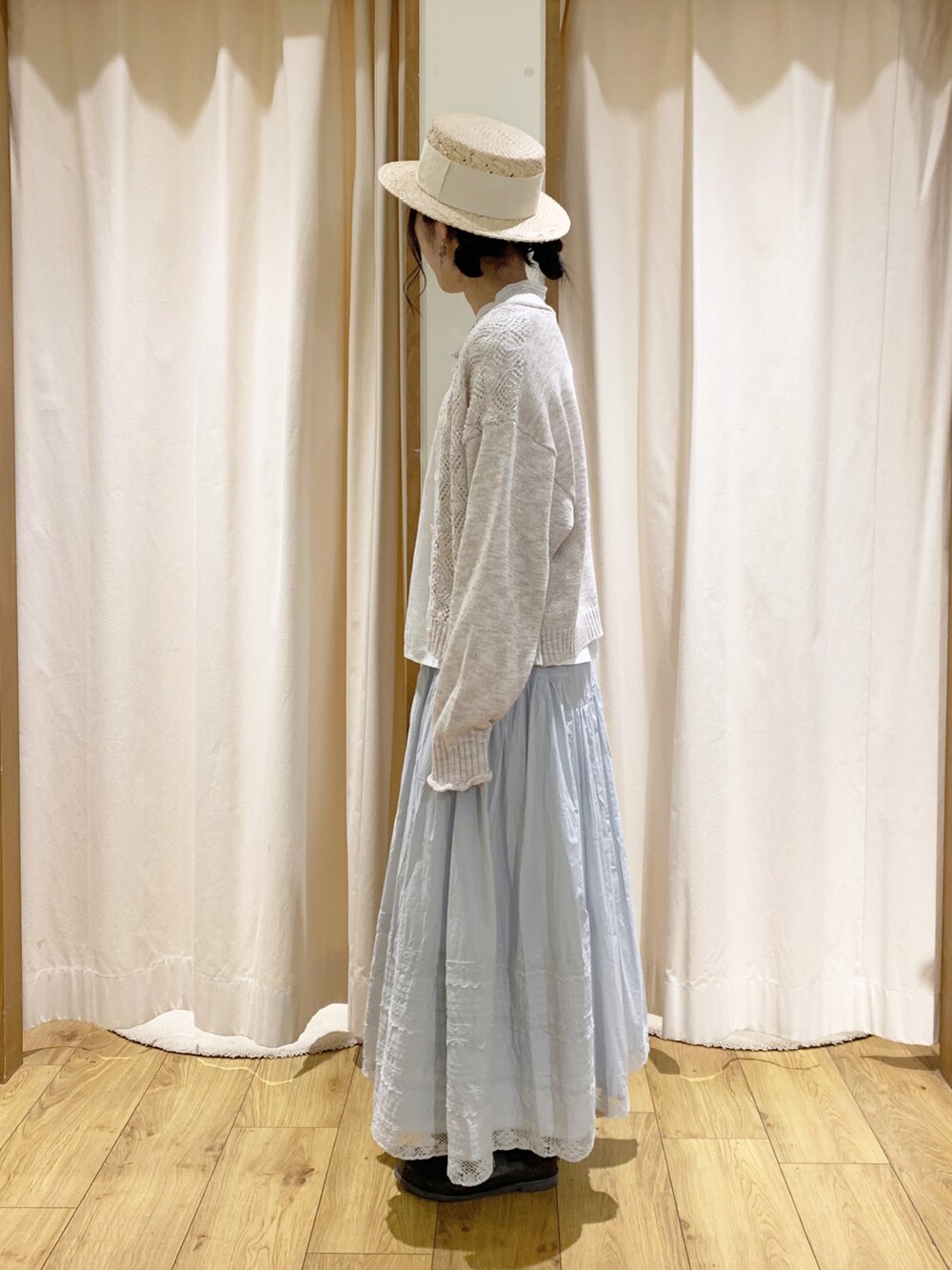 ホワイト系のカーディガン/ボレロ、ホワイト系のシャツ/ブラウス、ブルー系のスカートを着用したレディースの春コーディネートの3枚目の写真