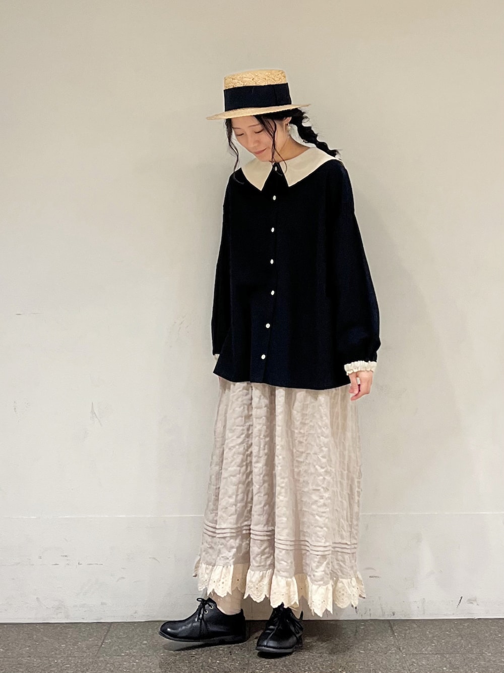 ブラック系のシャツ/ブラウス、ベージュ系のスカートを着用したレディースの冬コーディネートの2枚目の写真