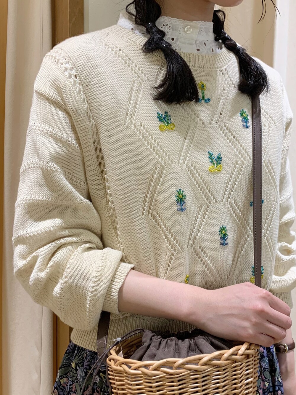 ブルー系のスカート、ホワイト系のニット/セーター、ホワイト系のチュニックを着用したレディースの春コーディネートの5枚目の写真