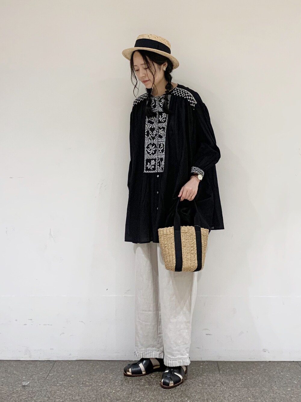 ブラック系のチュニック、ホワイト系のその他パンツ、ブラック系のタンクトップを着用したレディースの夏コーディネートの2枚目の写真