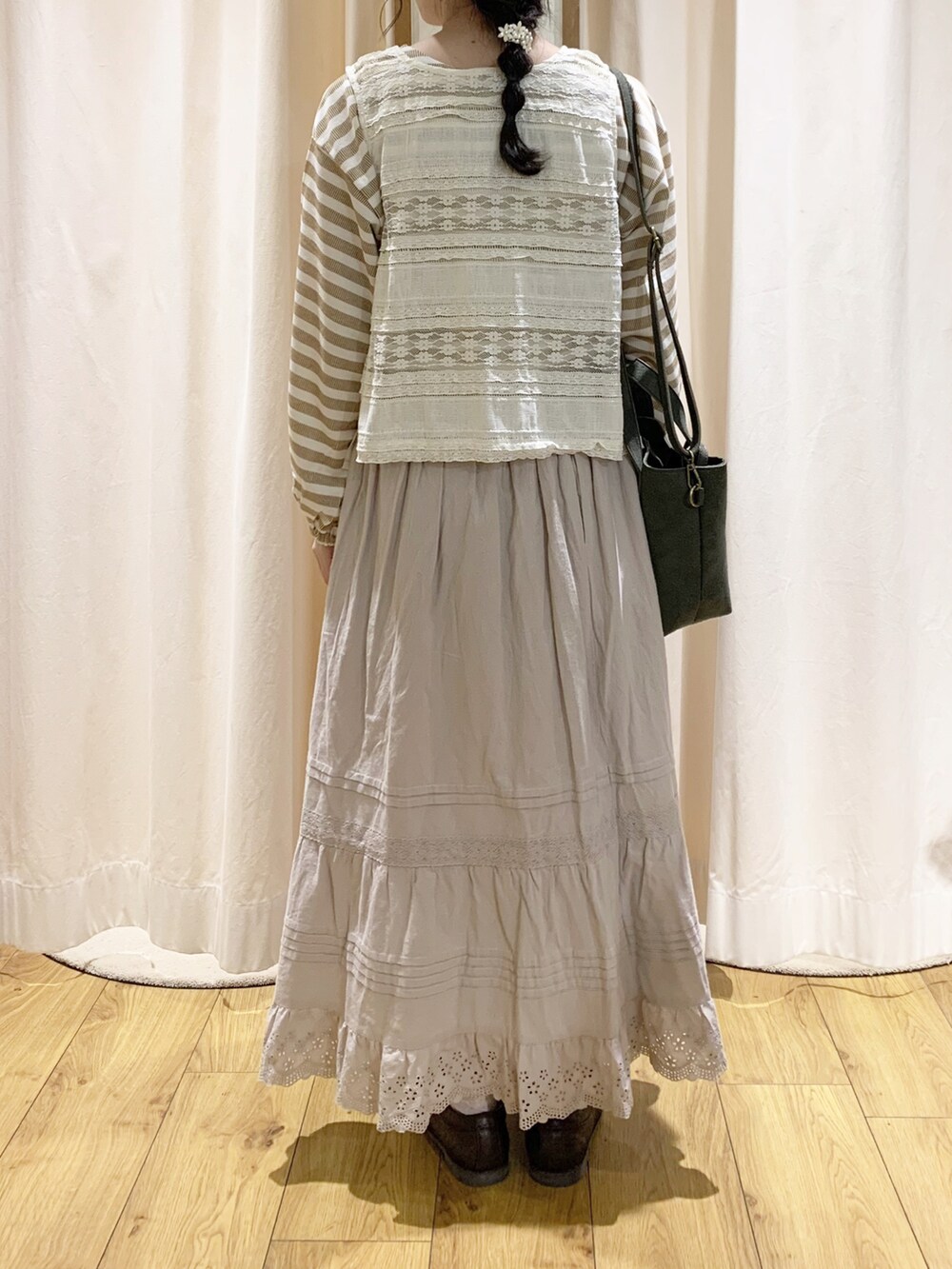 ホワイト系のベスト、イエロー系のTシャツ/カットソー、ホワイト系のスカートを着用したレディースの秋コーディネートの4枚目の写真