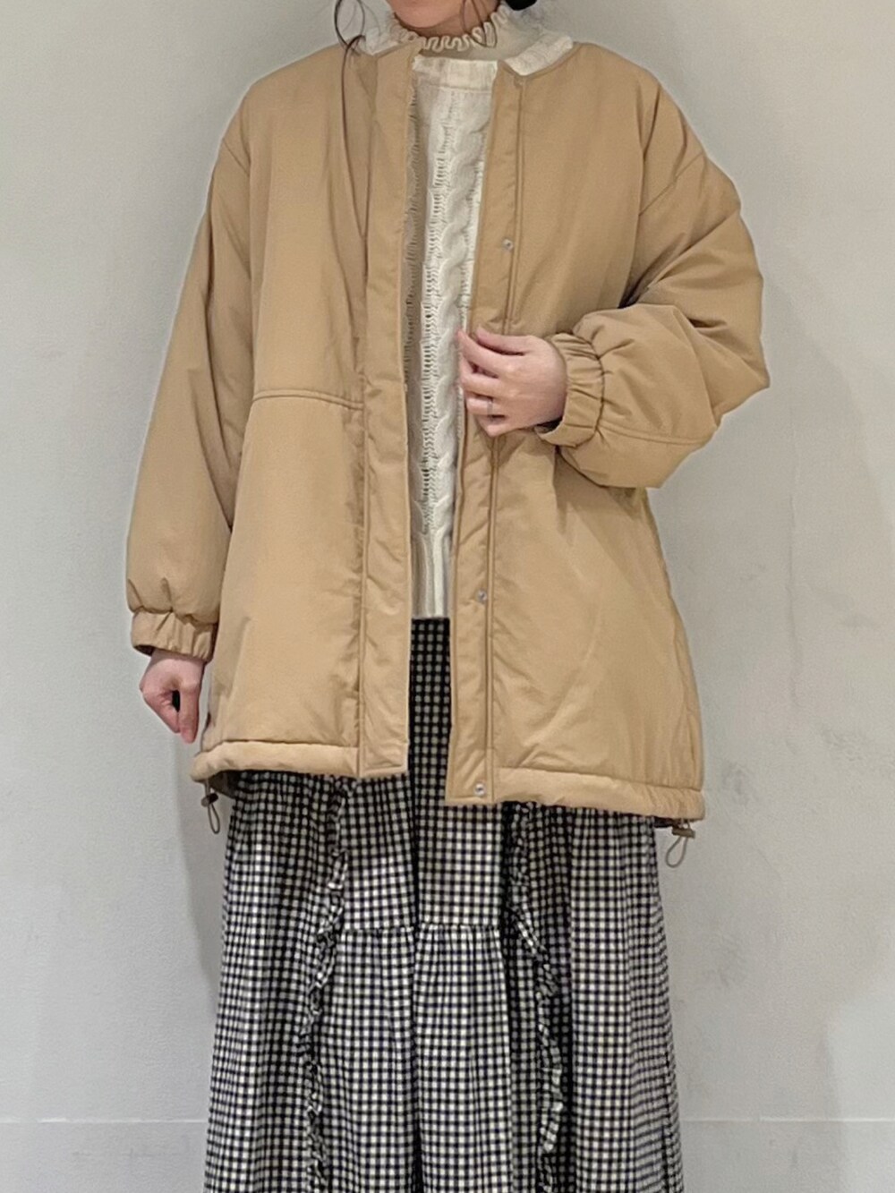 ホワイト系のニット/セーター、ホワイト系のカーディガン/ボレロ、ベージュ系のブルゾンを着用したレディースの冬コーディネートの4枚目の写真