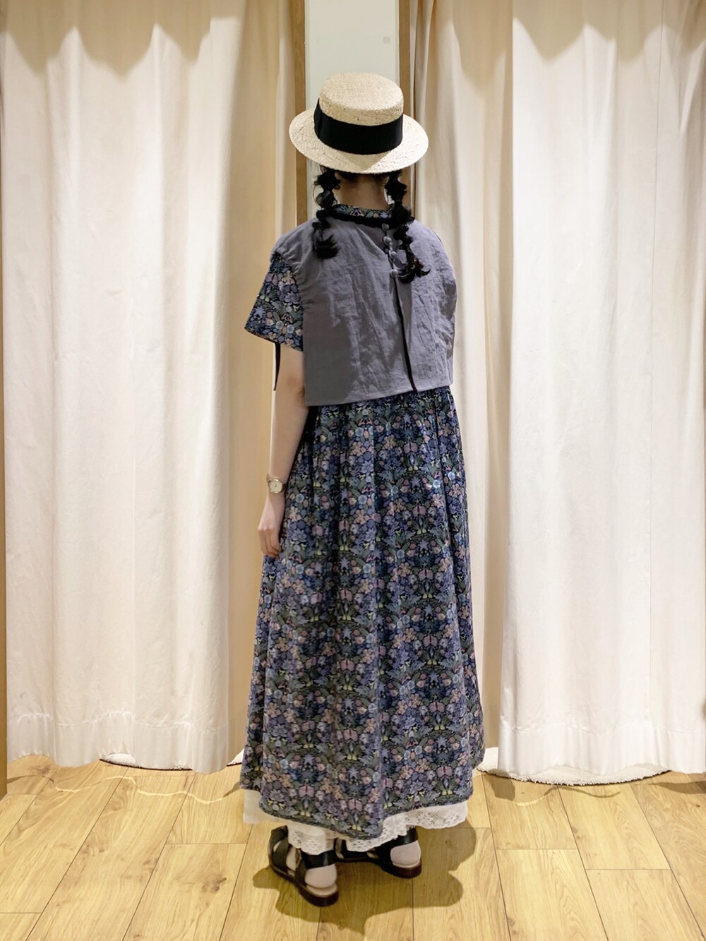 ブルー系のワンピース、グレー系のベスト、ホワイト系のスカートを着用したレディースの春コーディネートの3枚目の写真