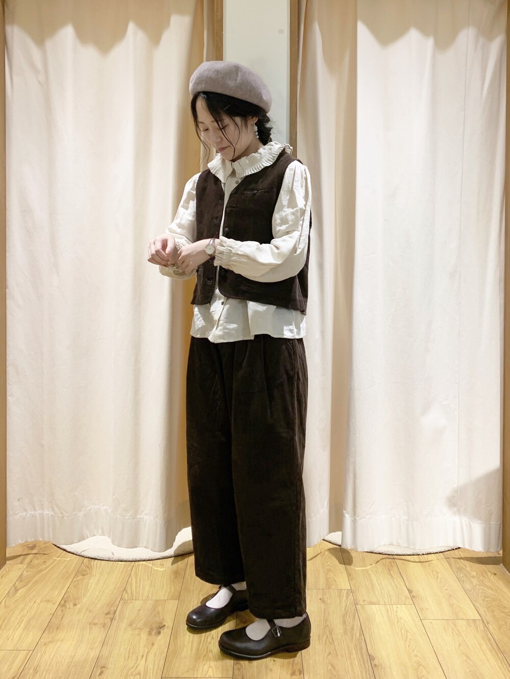 ブラウン系のベスト、ブラウン系のその他パンツ、ホワイト系のシャツ/ブラウスを着用したレディースの秋コーディネートの2枚目の写真