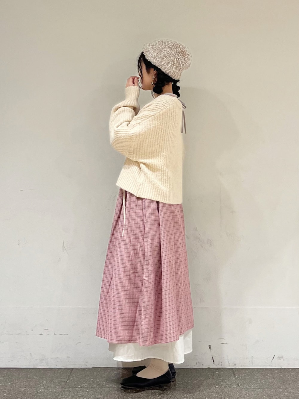 レッド系のワンピース、ホワイト系のカーディガン/ボレロ、ホワイト系のスカートを着用したレディースの冬コーディネートの3枚目の写真