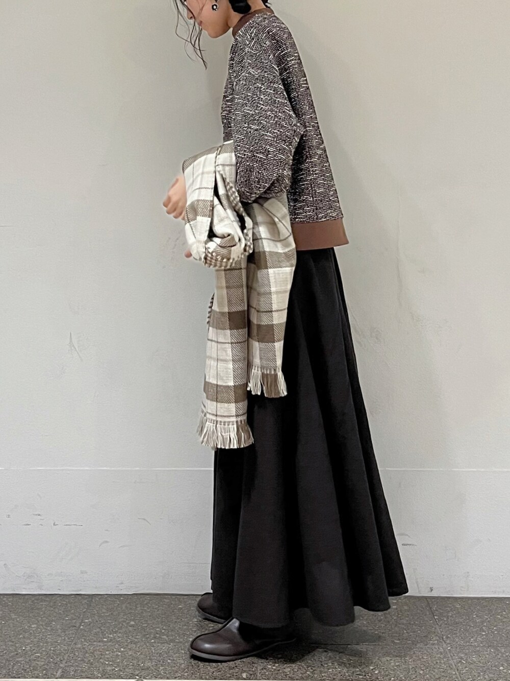 ブラウン系のTシャツ/カットソー、グレー系のスカート、ベージュ系のストール/ショールを着用したレディースの秋コーディネートの5枚目の写真