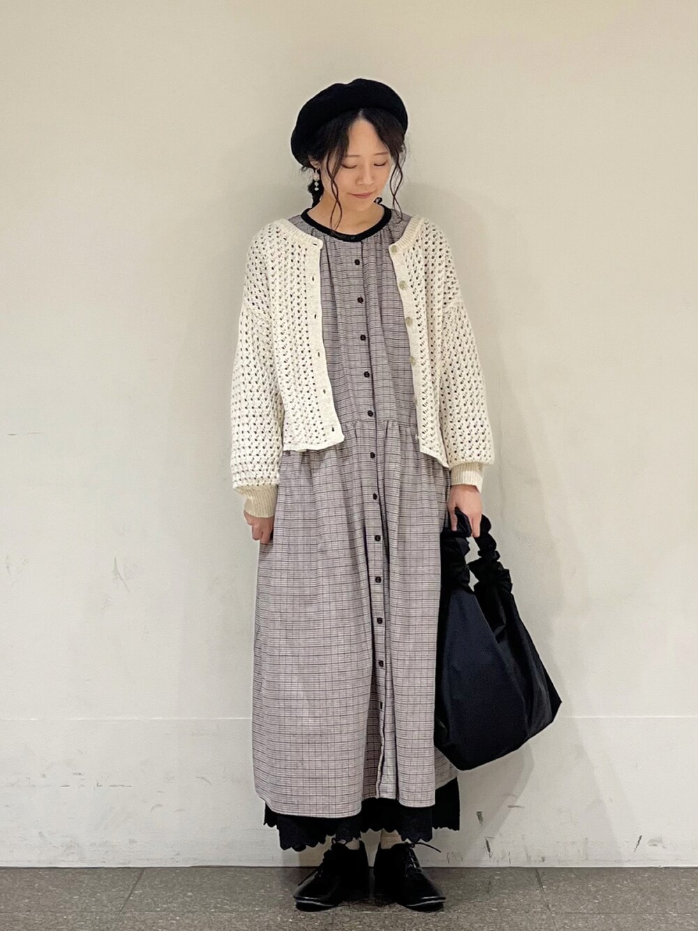 ブラック系のワンピース、ベージュ系のカーディガン/ボレロ、ブラック系のスカートを着用したレディースの冬コーディネートの2枚目の写真