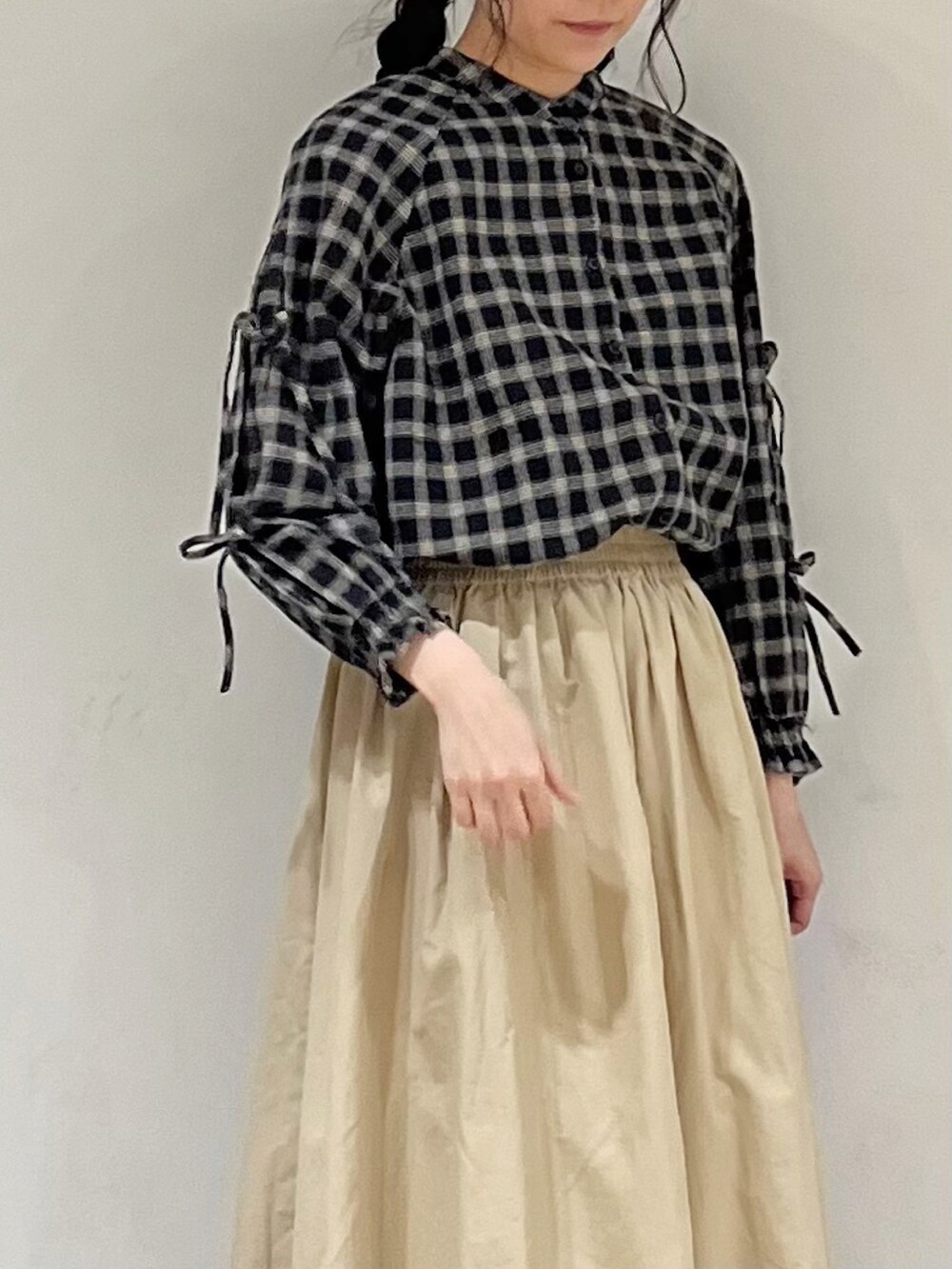 ブラック系のシャツ/ブラウス、ベージュ系のスカート、ブラック系のハットを着用したレディースの冬コーディネートの5枚目の写真