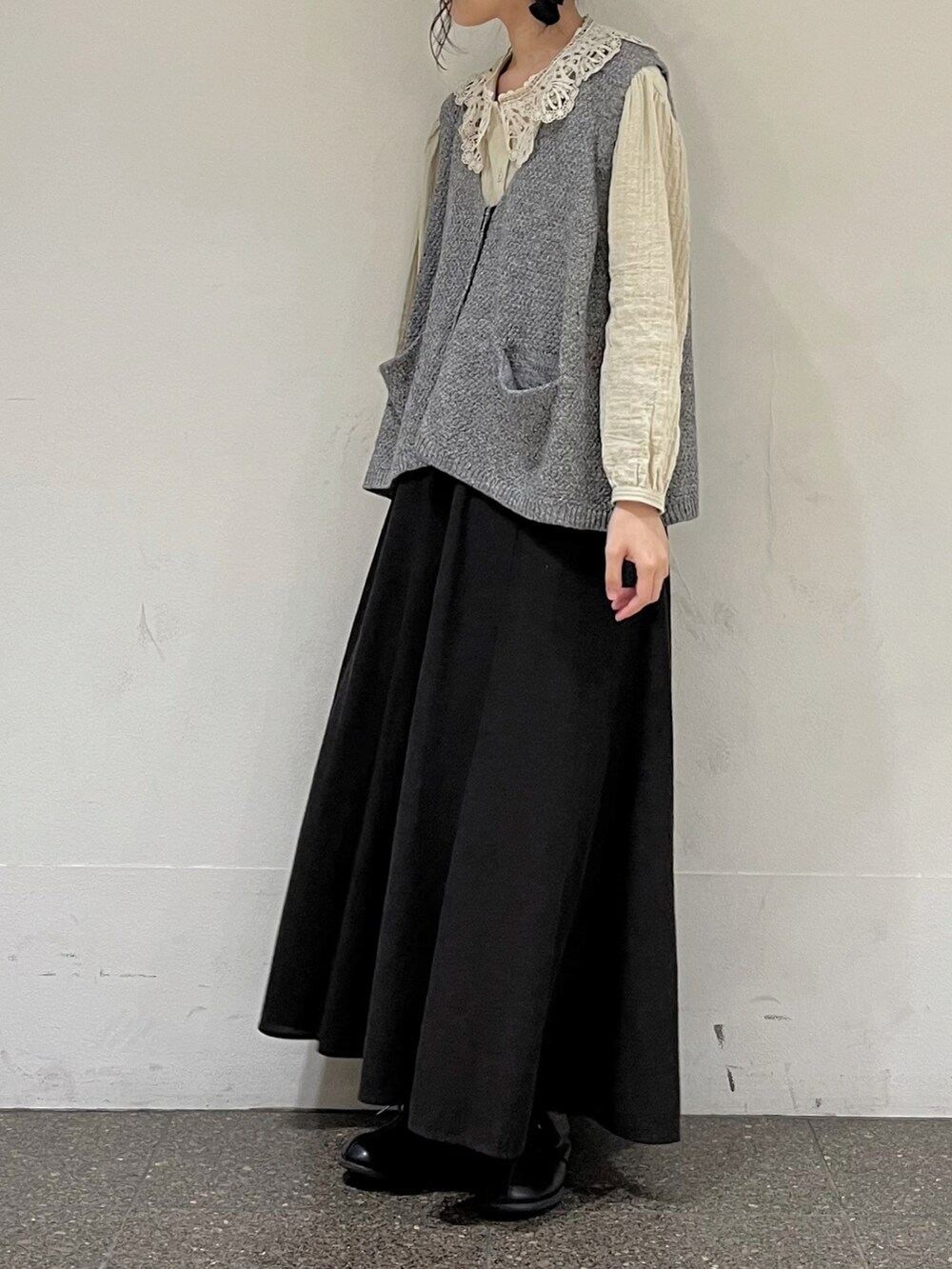 グレー系のベスト、ベージュ系のシャツ/ブラウス、グレー系のスカートを着用したレディースの秋コーディネートの4枚目の写真