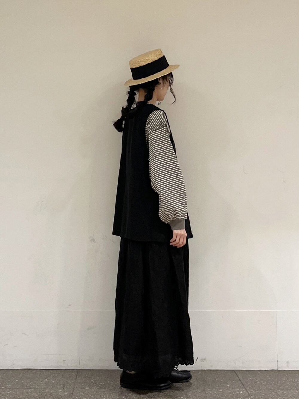 ブラウン系のTシャツ/カットソー、グレー系のベスト、ブラック系のスカートを着用したレディースの春コーディネートの2枚目の写真