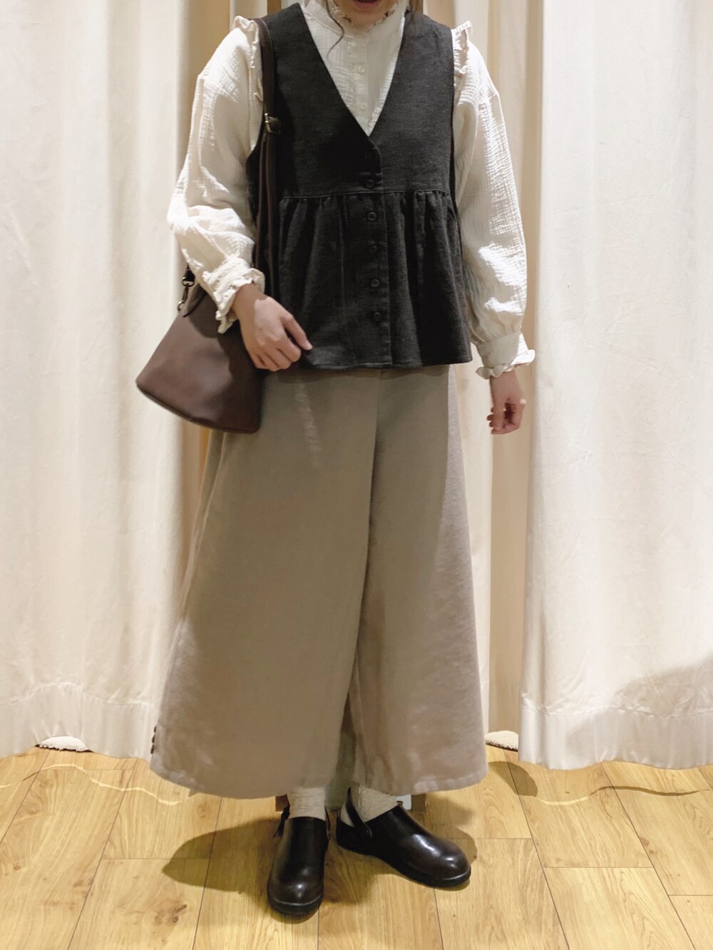 ブラウン系のベスト、ホワイト系のシャツ/ブラウス、ホワイト系のTシャツ/カットソーを着用したレディースの秋コーディネートの4枚目の写真