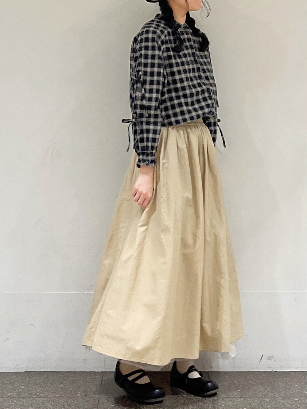 ブラック系のシャツ/ブラウス、ベージュ系のスカート、ブラック系のハットを着用したレディースの冬コーディネートの4枚目の写真