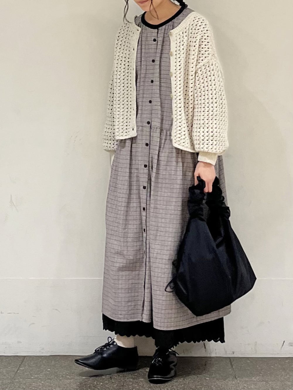 ブラック系のワンピース、ベージュ系のカーディガン/ボレロ、ブラック系のスカートを着用したレディースの冬コーディネートの3枚目の写真