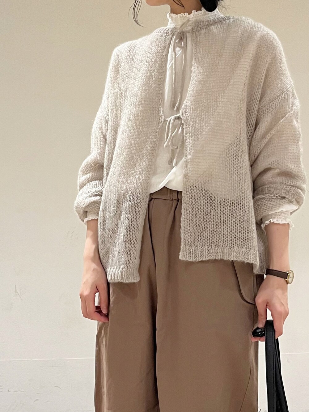 ブラウン系のその他パンツ、ブラック系のハンドバッグ、グレー系のカーディガン/ボレロを着用したレディースの冬コーディネートの5枚目の写真