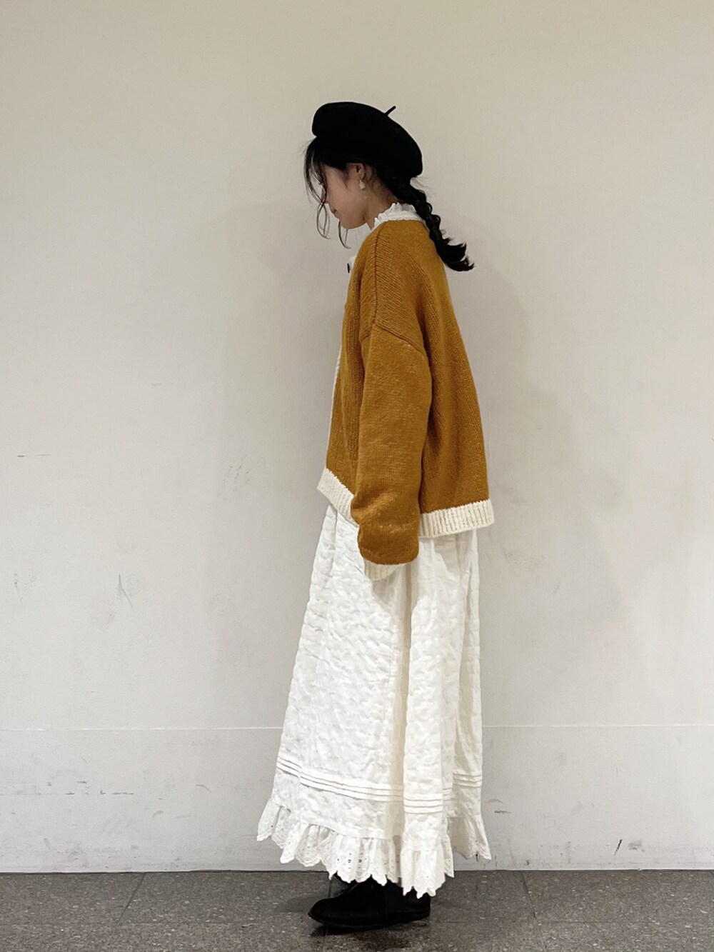 ホワイト系のシャツ/ブラウス、イエロー系のカーディガン/ボレロ、ホワイト系のスカートを着用したレディースの冬コーディネートの3枚目の写真