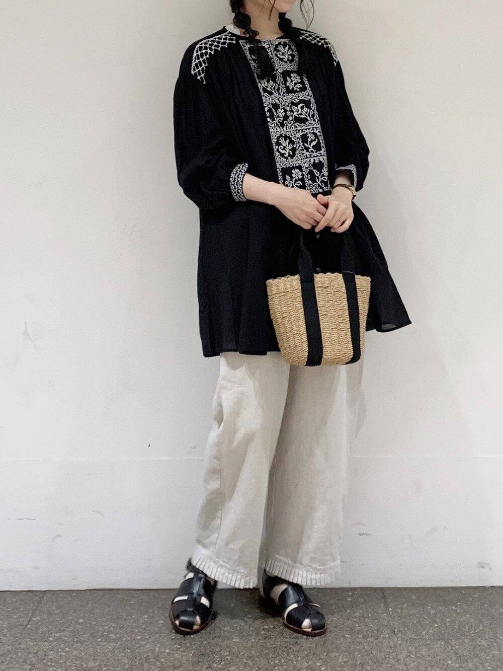 ブラック系のチュニック、ホワイト系のその他パンツ、ブラック系のタンクトップを着用したレディースの夏コーディネートの5枚目の写真