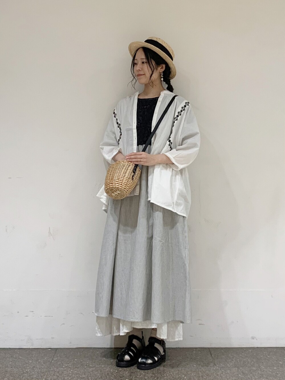 ブラック系のワンピース、ホワイト系のシャツ/ブラウス、ホワイト系のタンクトップを着用したレディースの春コーディネートの2枚目の写真