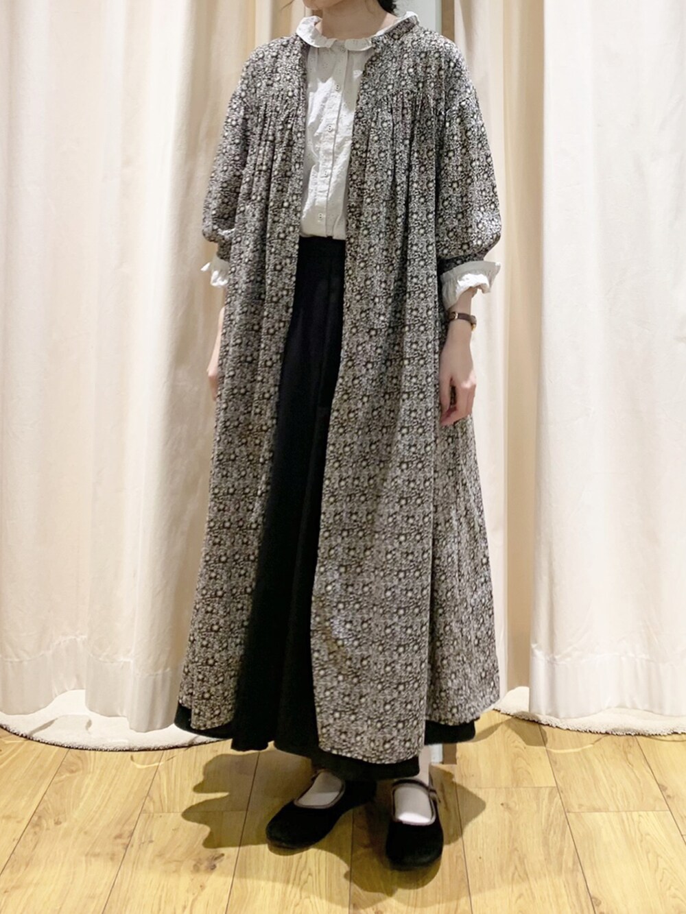 グレー系のワンピース、ホワイト系のシャツ/ブラウス、ブラック系のスカートを着用したレディースの秋コーディネートの2枚目の写真