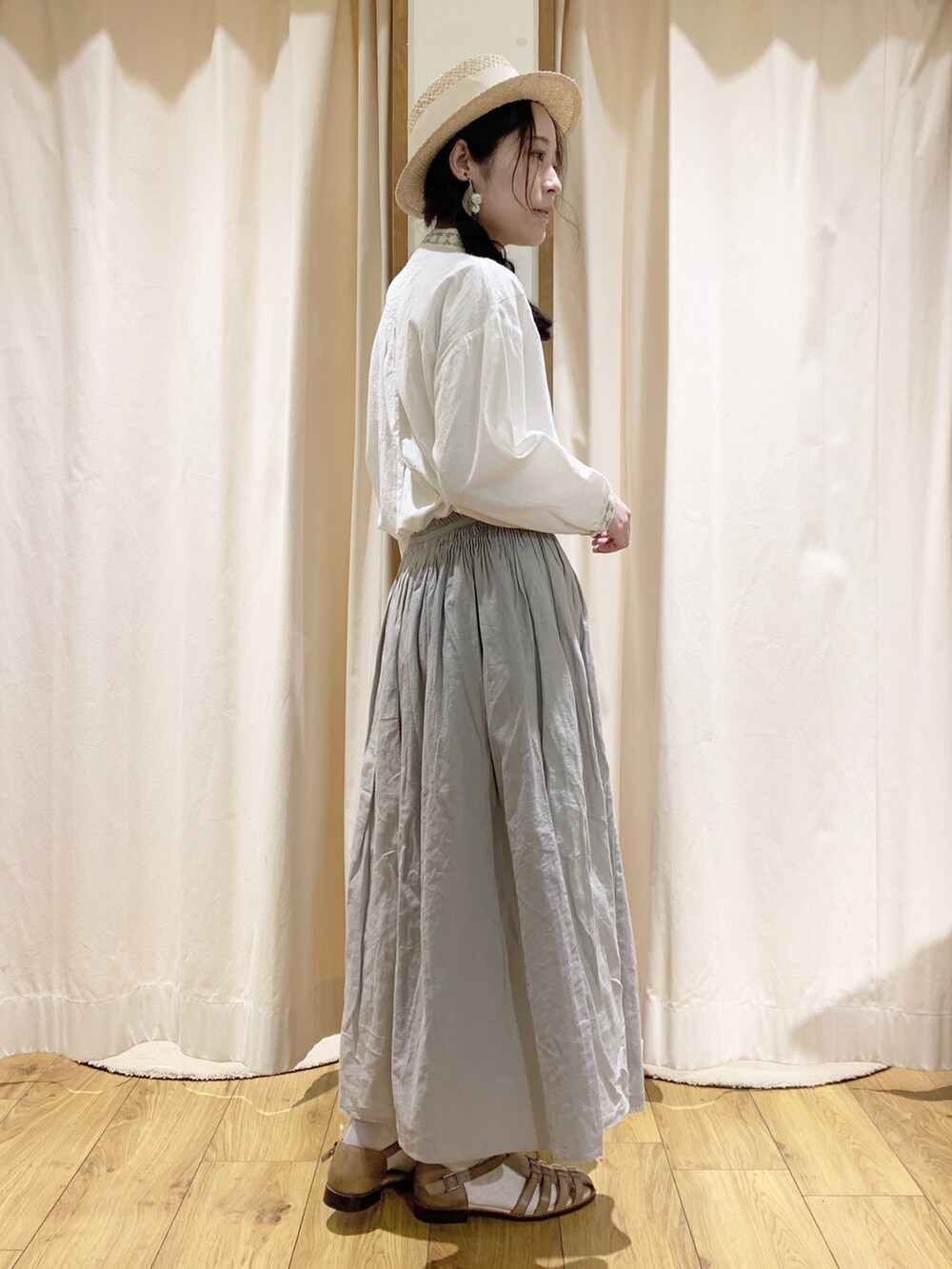 ホワイト系のシャツ/ブラウス、ホワイト系のカーディガン/ボレロ、グレー系のスカートを着用したレディースの春コーディネートの4枚目の写真