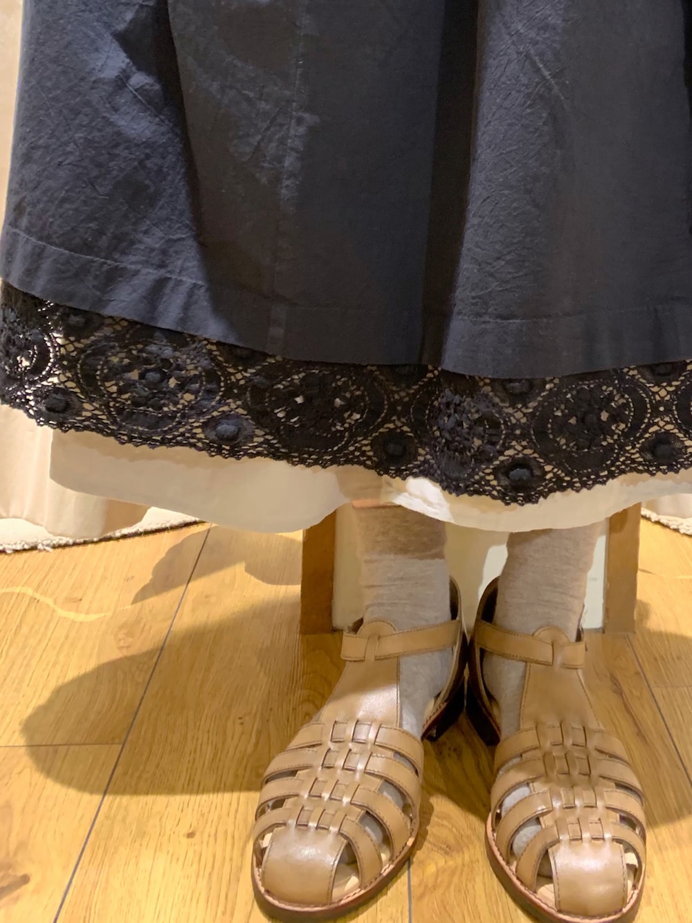 ブラック系のワンピース、グレー系のスカート、ベージュ系のサンダルを着用したレディースの春コーディネートの5枚目の写真