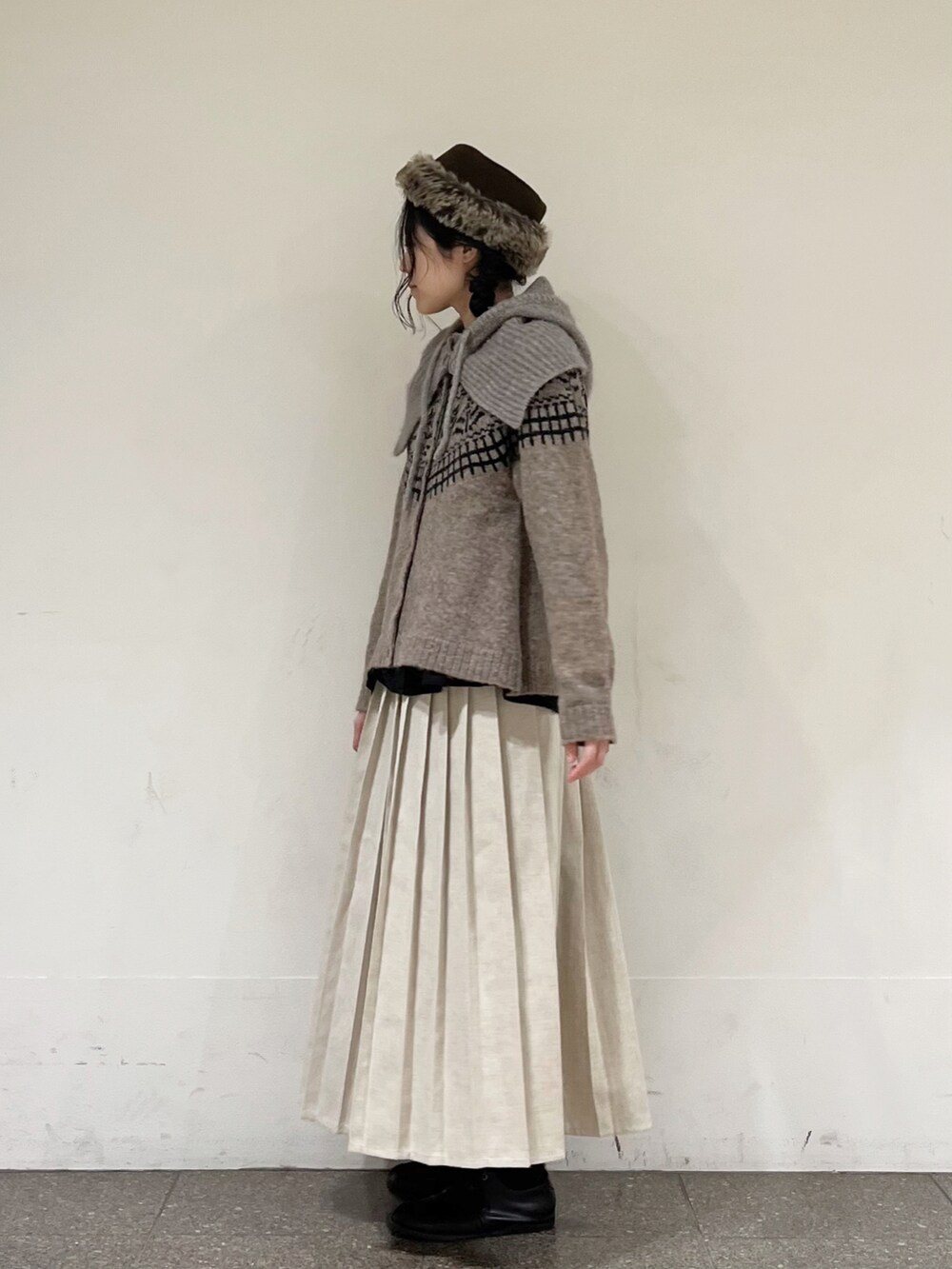 ブラウン系のカーディガン/ボレロ、ブラック系のシャツ/ブラウス、ベージュ系のスカートを着用したレディースの冬コーディネートの2枚目の写真