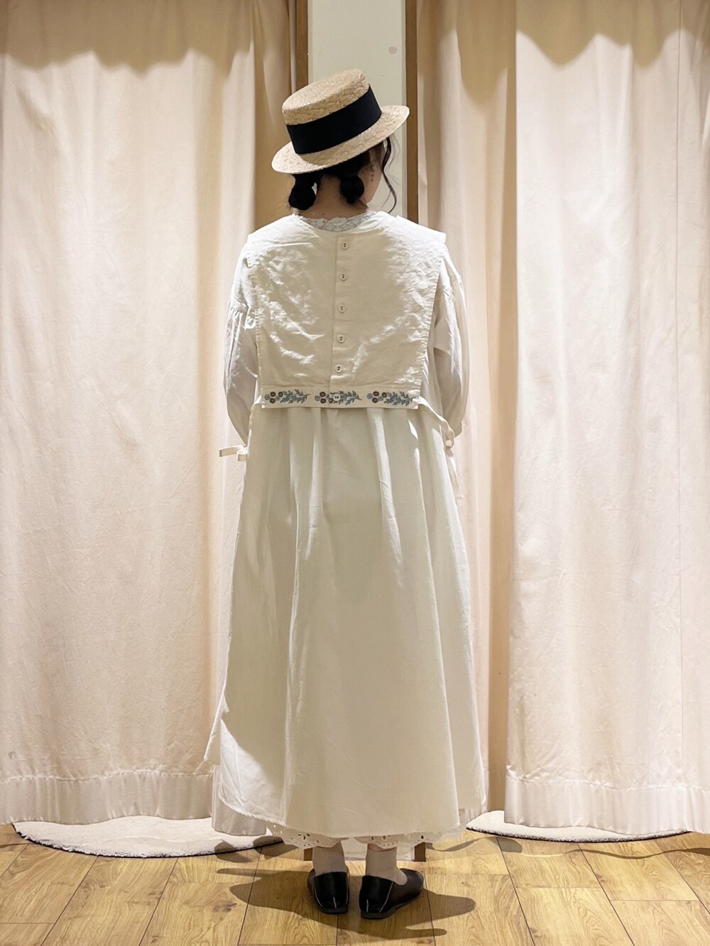 ホワイト系のベストを着用したレディースの春コーディネートの2枚目の写真