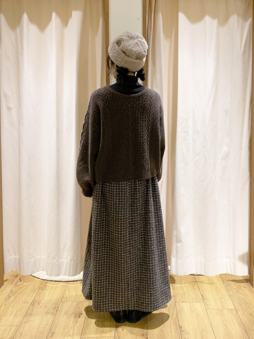 グレー系のニット/セーター、ブラウン系のカーディガン/ボレロ、ブラウン系のスカートを着用したレディースの冬コーディネートの4枚目の写真