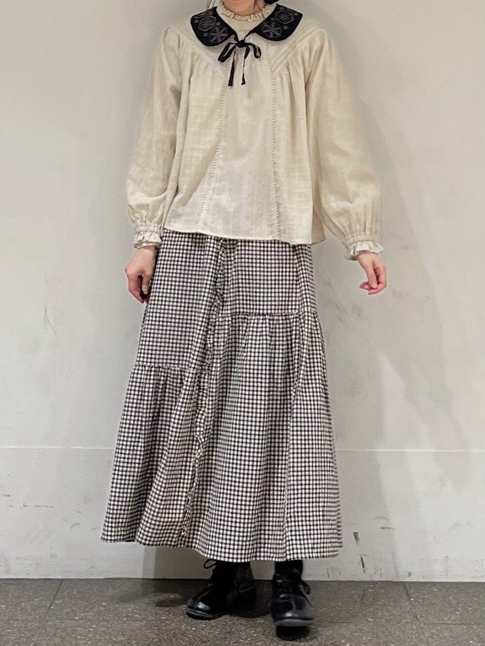 ベージュ系のシャツ/ブラウス、ブラック系のスカート、グレー系のカーディガン/ボレロを着用したレディースの冬コーディネートの4枚目の写真