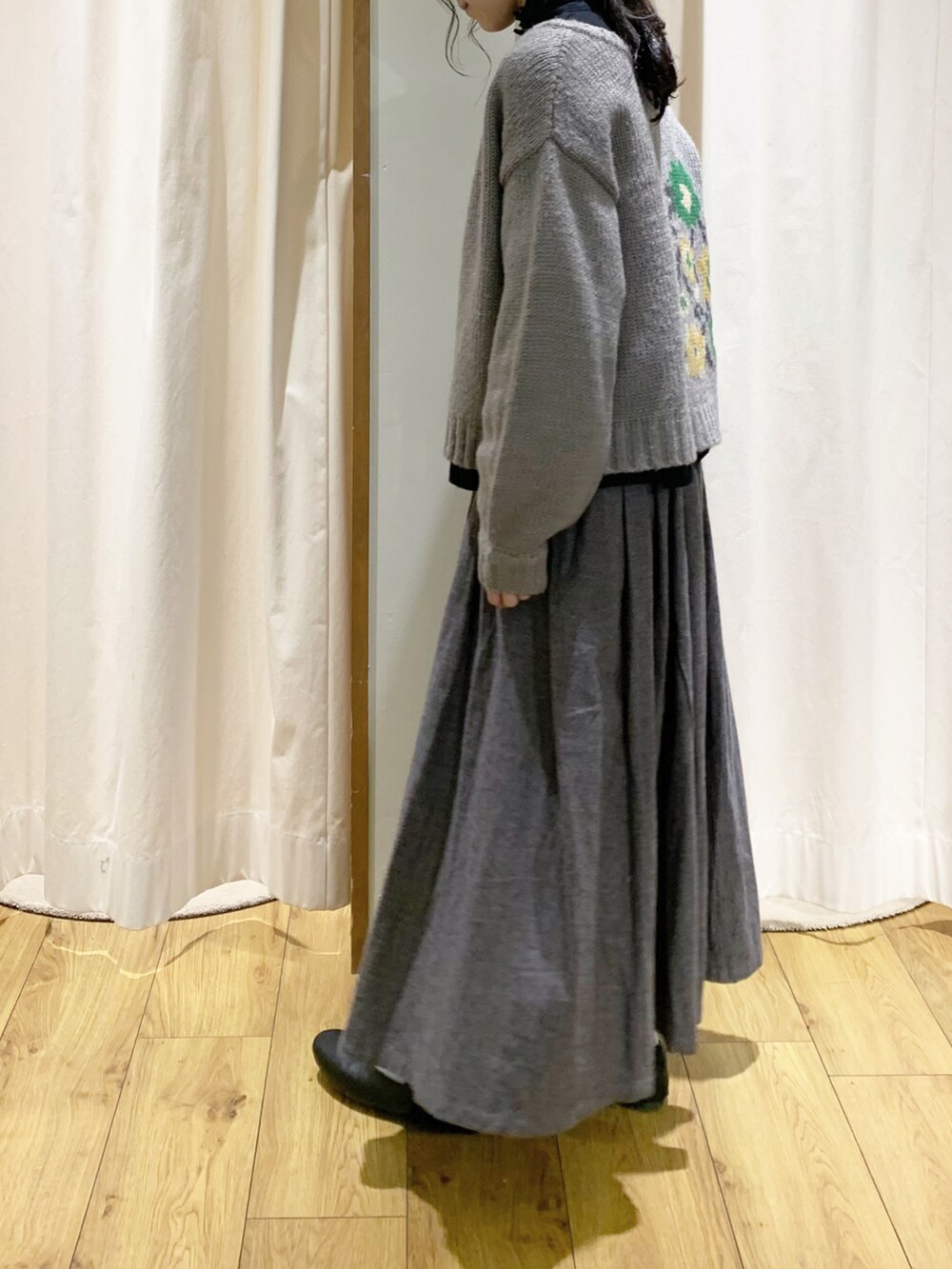 グレー系のカーディガン/ボレロ、ブラック系のシャツ/ブラウス、グレー系のスカートを着用したレディースの秋コーディネートの3枚目の写真