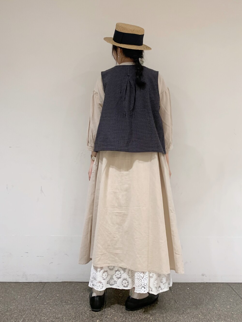 グレー系のベスト、ベージュ系のワンピース、ホワイト系のTシャツ/カットソーを着用したレディースの夏コーディネートの3枚目の写真