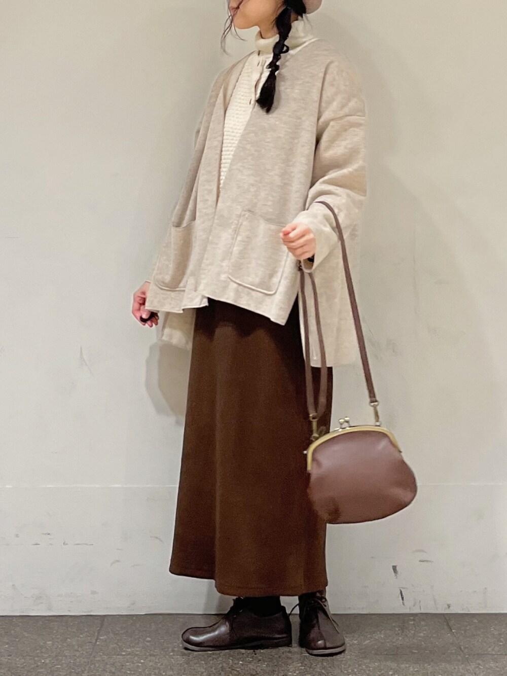 ブラウン系のスカート、ホワイト系のカーディガン/ボレロ、ベージュ系のノーカラージャケットを着用したレディースの秋コーディネートの4枚目の写真
