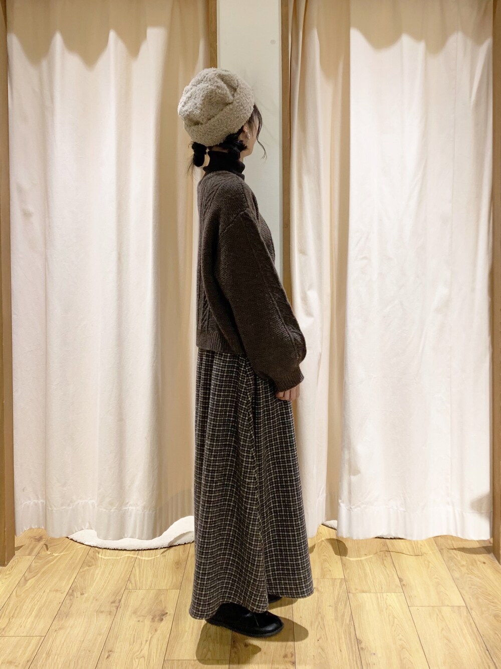 グレー系のニット/セーター、ブラウン系のカーディガン/ボレロ、ブラウン系のスカートを着用したレディースの冬コーディネートの3枚目の写真