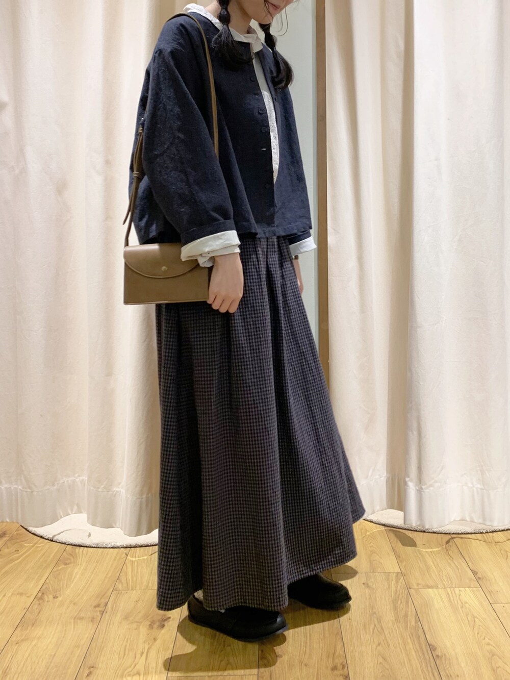 グレー系のノーカラージャケット、ホワイト系のシャツ/ブラウス、グレー系のスカートを着用したレディースの秋コーディネートの2枚目の写真