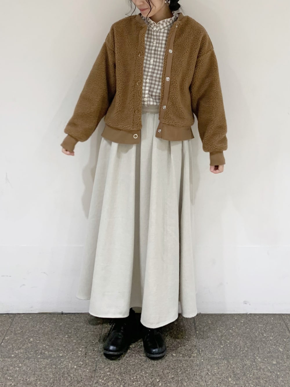 イエロー系のブルゾン、ベージュ系のシャツ/ブラウス、ベージュ系のスカートを着用したレディースの冬コーディネートの2枚目の写真